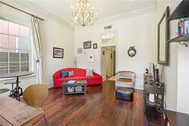 living room with an inviting chandelier, ornamental molding, and dark hardwood / wood-style floors