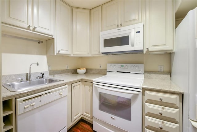 kitchen with sink, light stone counters, and white appliances