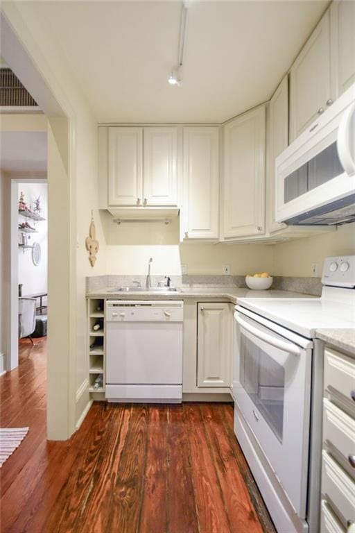 kitchen with white appliances, dark hardwood / wood-style flooring, sink, and white cabinets