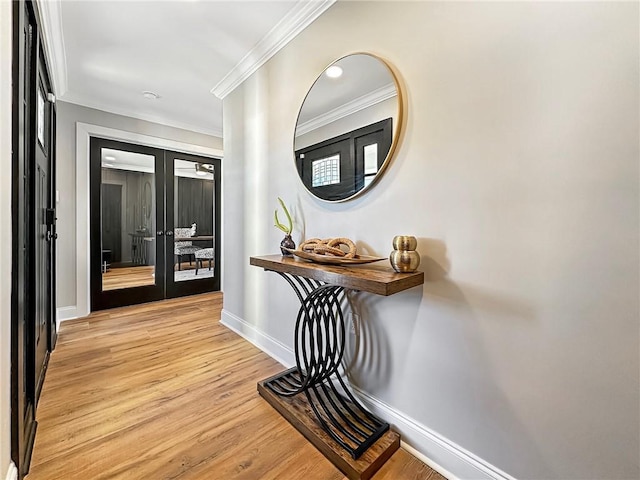 corridor featuring light hardwood / wood-style flooring, ornamental molding, and french doors