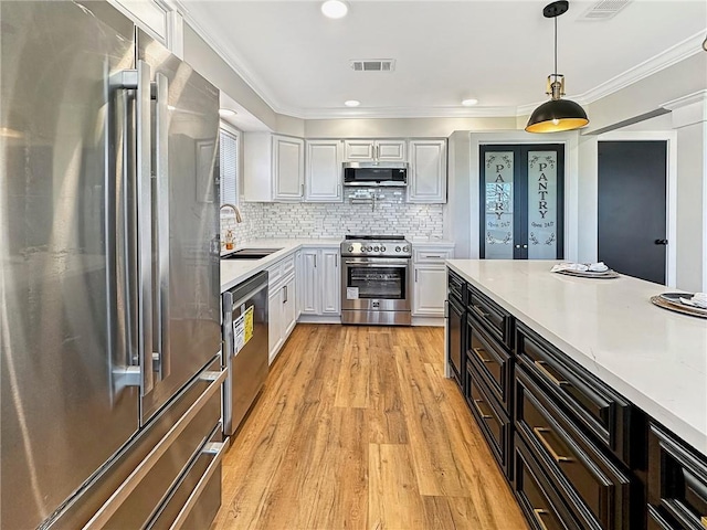 kitchen featuring white cabinetry, sink, backsplash, and appliances with stainless steel finishes