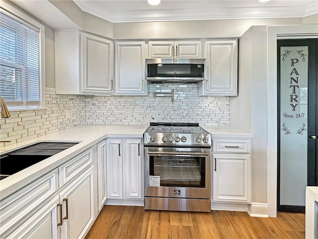 kitchen with white cabinetry, stainless steel appliances, and backsplash