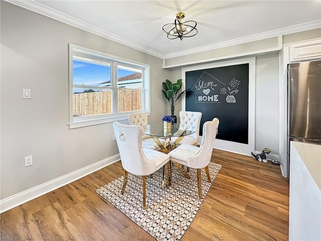 dining space featuring an inviting chandelier, hardwood / wood-style flooring, and ornamental molding