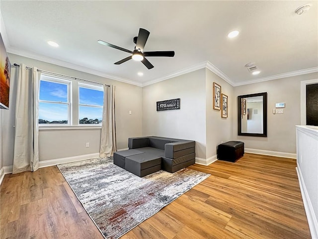 living area featuring ornamental molding, light hardwood / wood-style floors, and ceiling fan