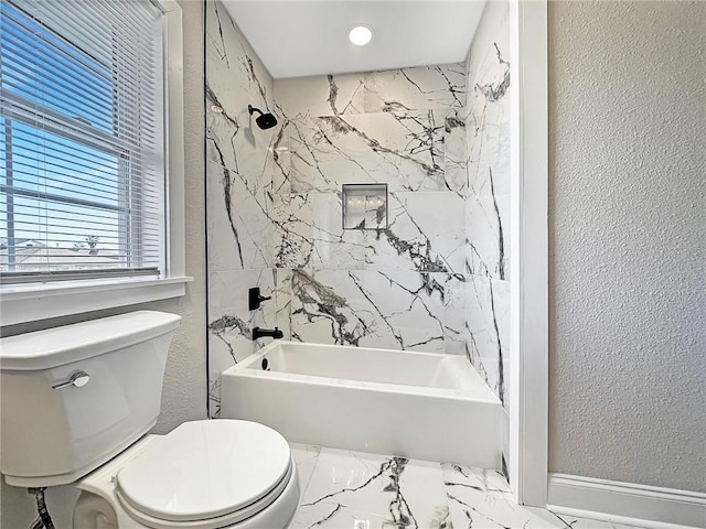 bathroom featuring toilet and tiled shower / bath combo