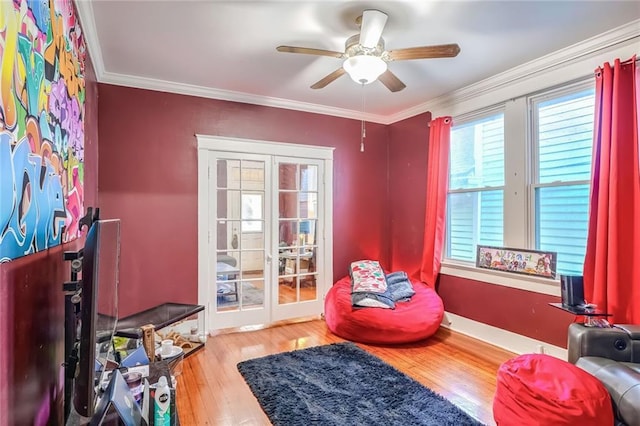 living area featuring crown molding, a healthy amount of sunlight, and wood-type flooring