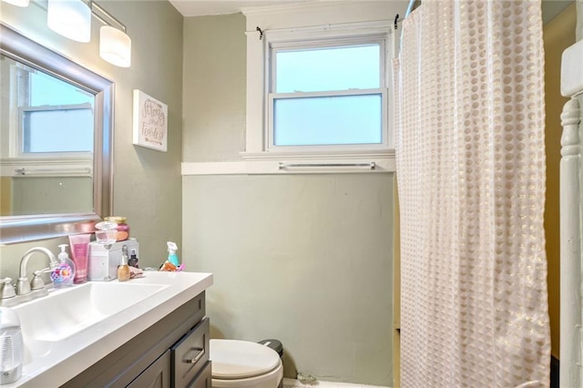 bathroom with a healthy amount of sunlight, toilet, a shower with shower curtain, and vanity