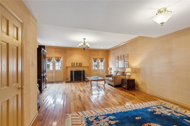 unfurnished living room with an inviting chandelier, crown molding, and hardwood / wood-style floors