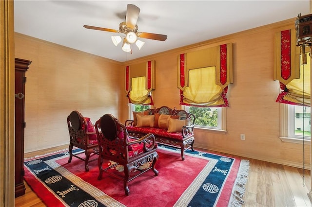 living area with hardwood / wood-style floors and ceiling fan