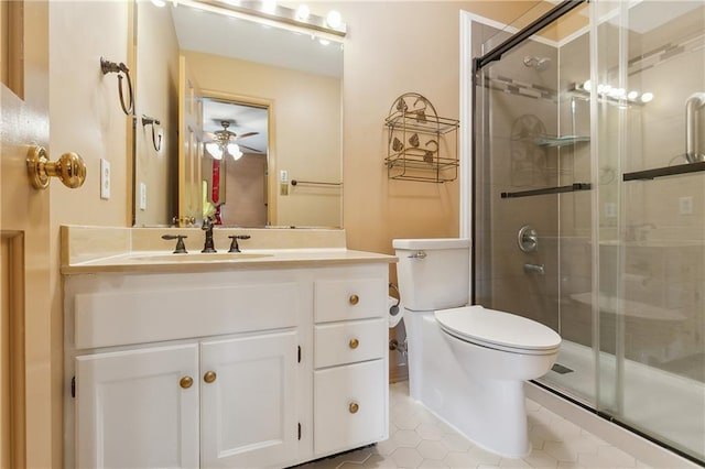 bathroom featuring a shower with door, vanity, tile patterned floors, and toilet