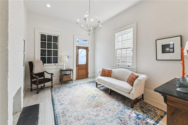 living area with an inviting chandelier and light hardwood / wood-style floors