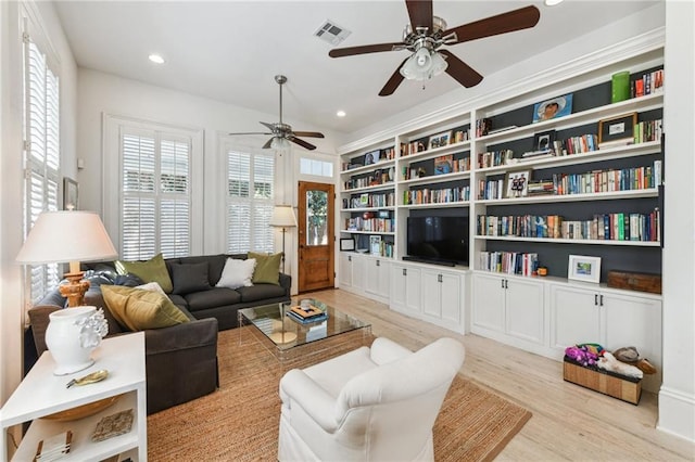 living room with built in features and light hardwood / wood-style flooring