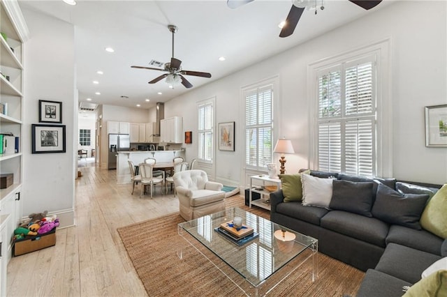 living room with ceiling fan and light wood-type flooring