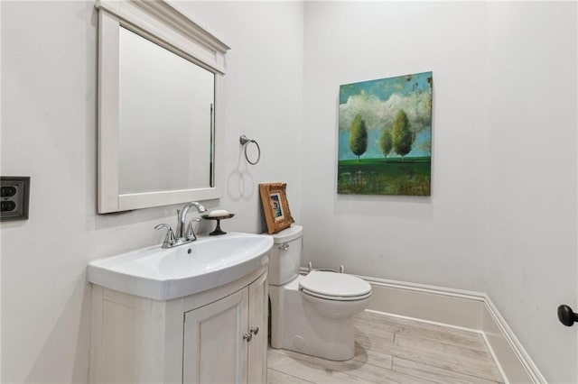 bathroom with vanity, wood-type flooring, and toilet