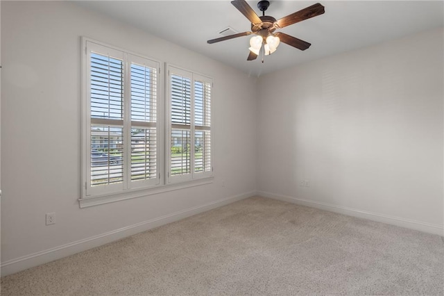 empty room featuring ceiling fan and light carpet