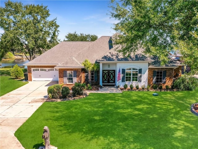 view of front of house featuring a garage, a front yard, and a water view