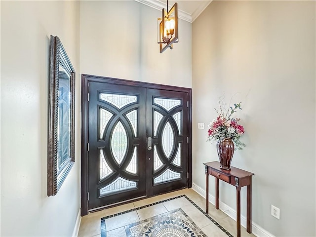 tiled entryway with french doors and crown molding