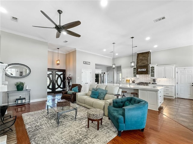 living room with crown molding, dark wood-type flooring, sink, and ceiling fan