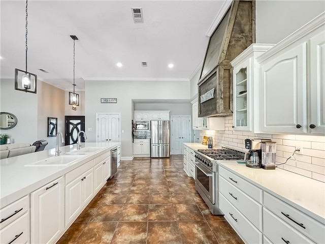 kitchen with hanging light fixtures, appliances with stainless steel finishes, sink, and white cabinets