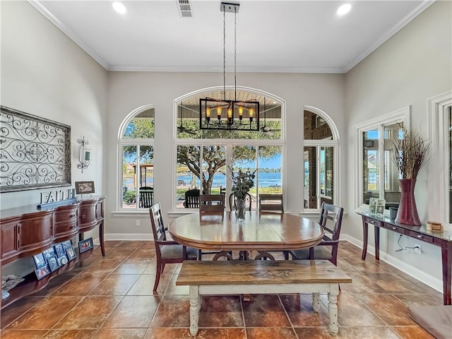 dining room featuring crown molding, a towering ceiling, and an inviting chandelier