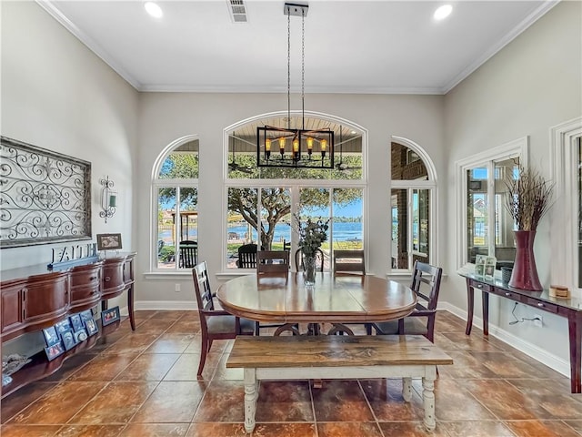 dining area featuring ornamental molding, a towering ceiling, and an inviting chandelier