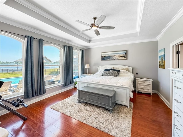 bedroom with dark hardwood / wood-style flooring, a textured ceiling, a raised ceiling, and ceiling fan