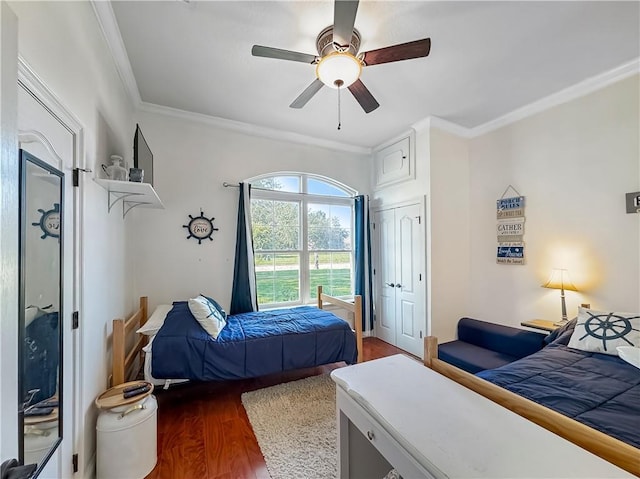 bedroom with dark hardwood / wood-style flooring, crown molding, and ceiling fan