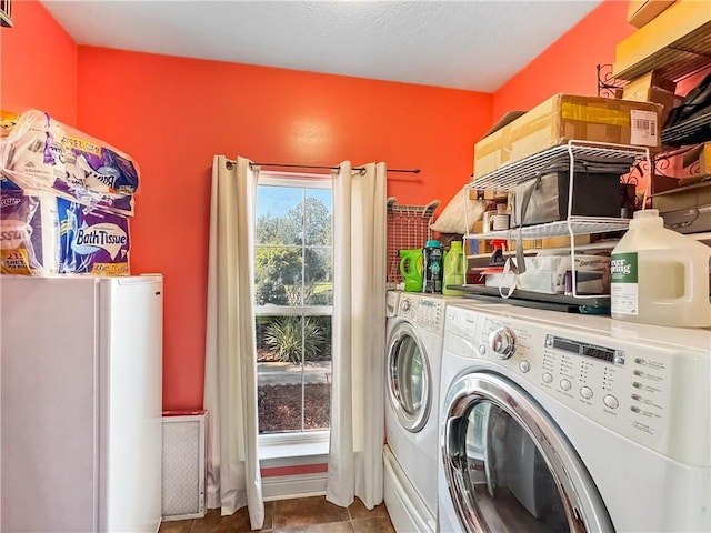 clothes washing area featuring tile patterned floors and washer and clothes dryer