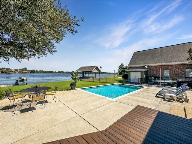 view of pool featuring a water view, a yard, and a patio area