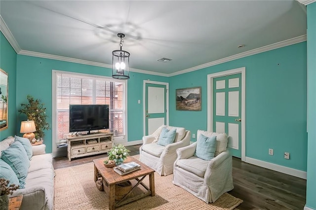 living room with ornamental molding, wood-type flooring, and a chandelier