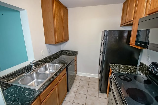 kitchen featuring sink, light tile patterned floors, dark stone counters, and black appliances