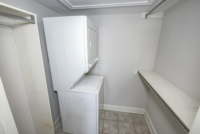 clothes washing area featuring stacked washer / drying machine and light tile patterned floors