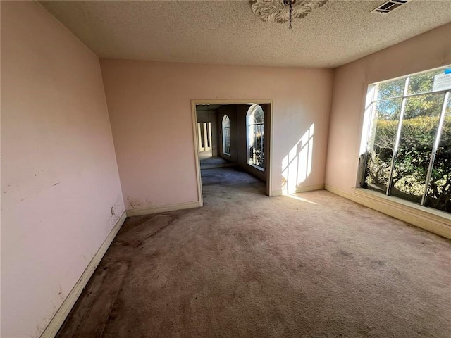 carpeted empty room with a textured ceiling