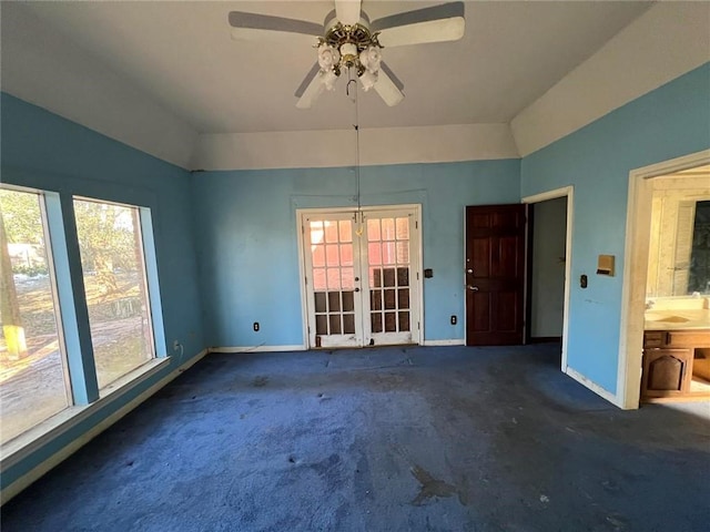 carpeted empty room with french doors, ceiling fan, and vaulted ceiling