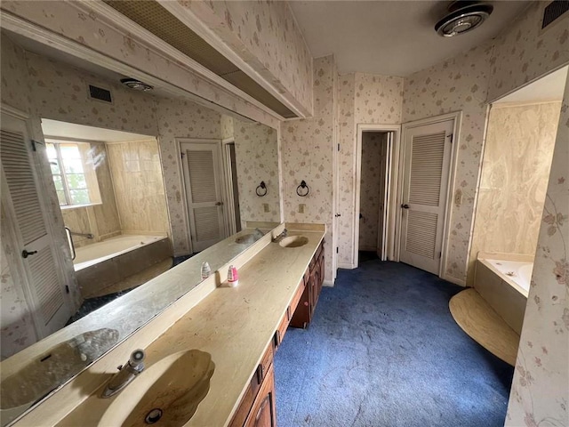 bathroom with vanity and a bath