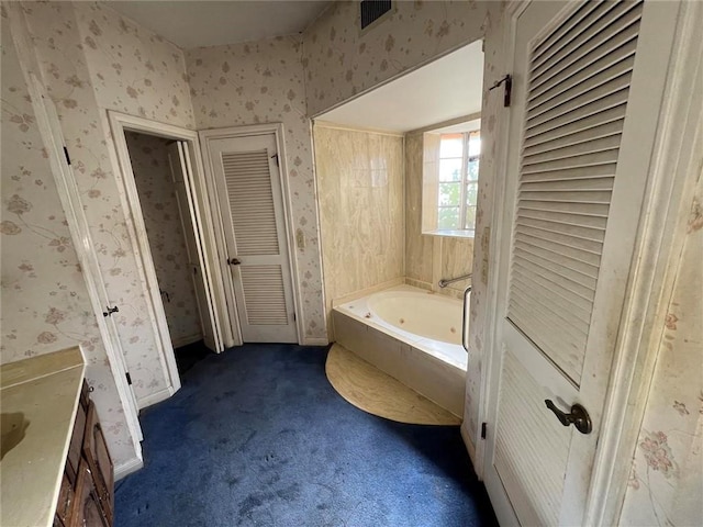 bathroom featuring vanity and a tub to relax in