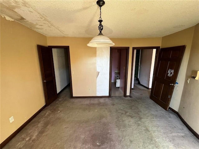 unfurnished dining area with dark carpet and a textured ceiling