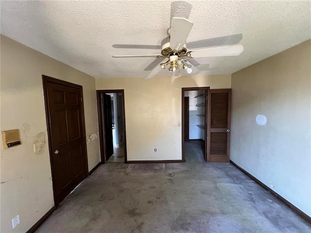 spare room with ceiling fan, a textured ceiling, and concrete floors