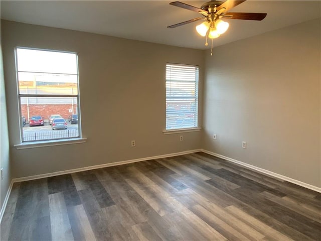 spare room featuring dark wood-type flooring and ceiling fan