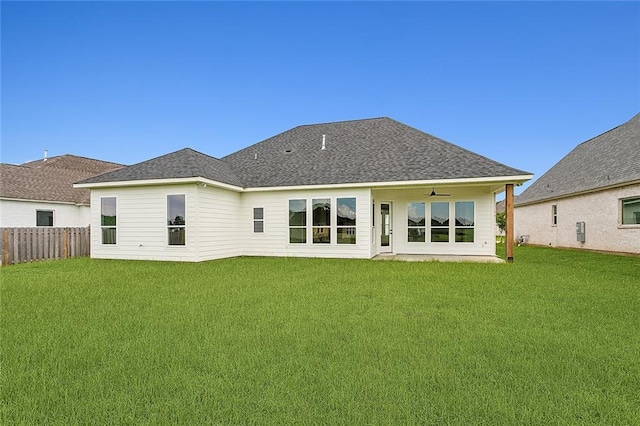 back of property featuring a yard and ceiling fan