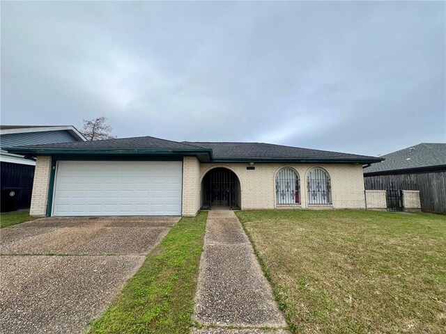 single story home featuring a garage and a front yard