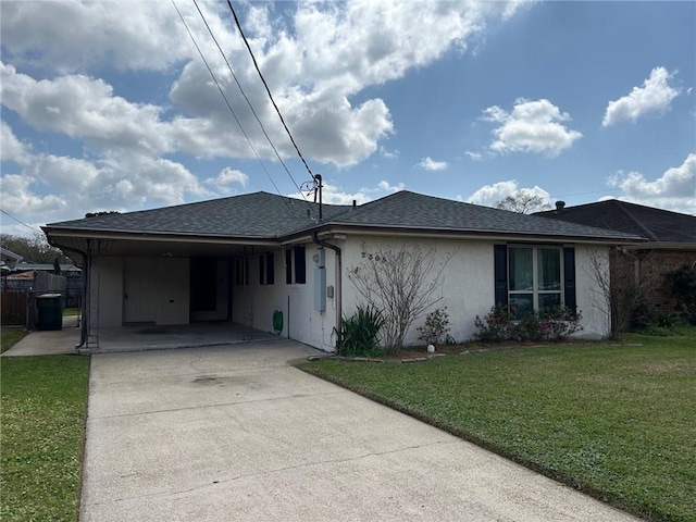 ranch-style home with stucco siding, a front lawn, roof with shingles, concrete driveway, and an attached carport