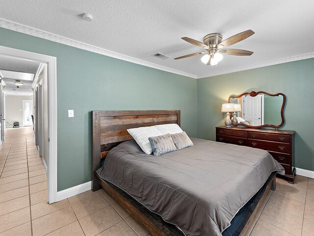 tiled bedroom featuring a textured ceiling, ornamental molding, and ceiling fan