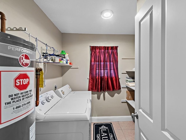 washroom featuring water heater, light tile patterned flooring, and washer and clothes dryer