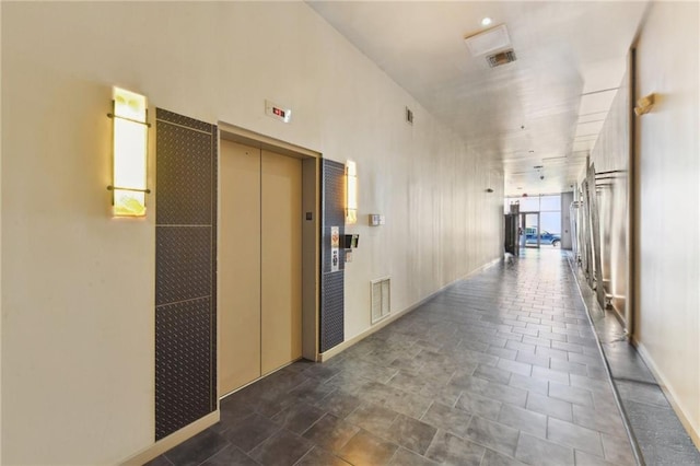 hallway featuring elevator and visible vents