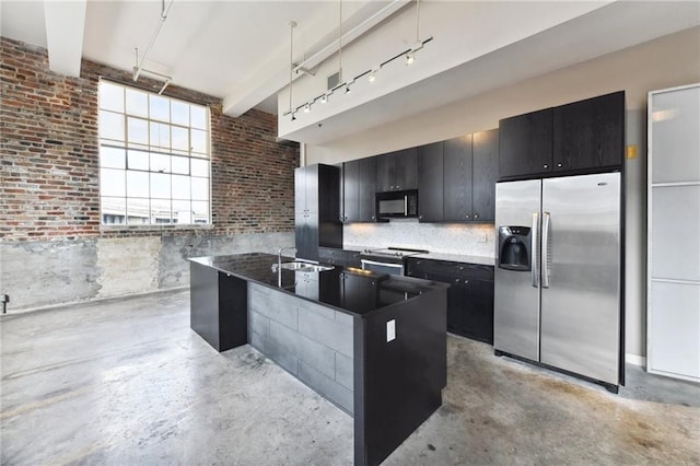 kitchen with brick wall, concrete floors, dark cabinets, and appliances with stainless steel finishes