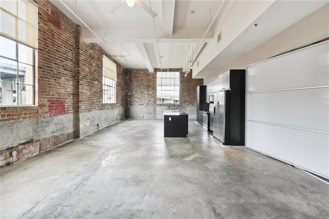 interior space featuring stainless steel fridge, ceiling fan, and visible vents