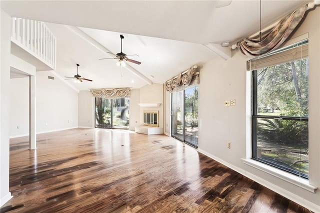 unfurnished living room with wood-type flooring, vaulted ceiling with beams, and ceiling fan