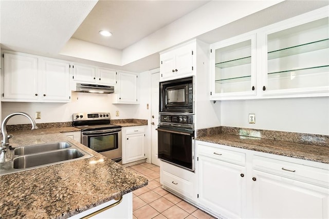 kitchen with sink, white cabinets, light tile patterned floors, black appliances, and a raised ceiling