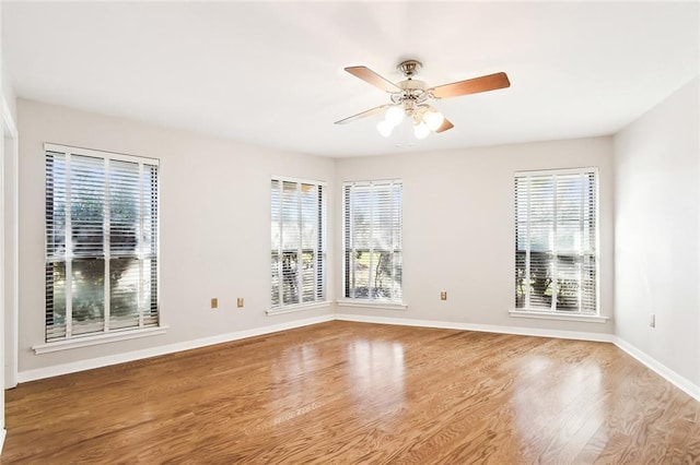 unfurnished room featuring plenty of natural light, ceiling fan, and light wood-type flooring